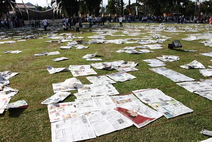 Sampah kertas koran berserakan di halaman kantor Gubernuran dan di sepanjang kawasan Sudirman setelah selesai Shalat. Masyarakat membiarkan saja koran bekas yang tadi mereka gunakan sebagai alas untuk shalat.