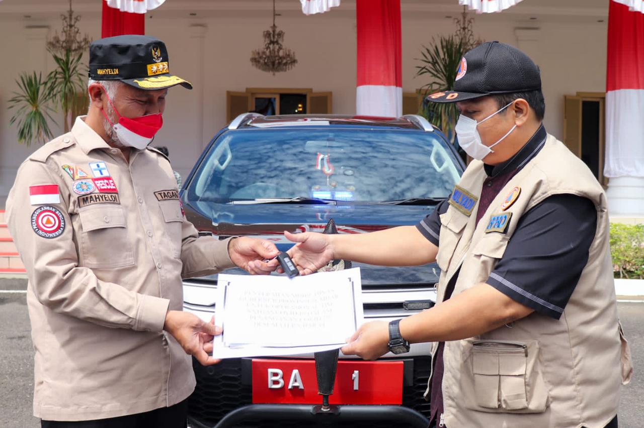 Gubernur Sumbar Mahyeldi (kiri) secara simbolis menyerahkan kunci mobil dinas baru untuk digunakan sebagai kendaraan operasional satgas COVID-19 Sumbar di Padang, Kamis. (hms)