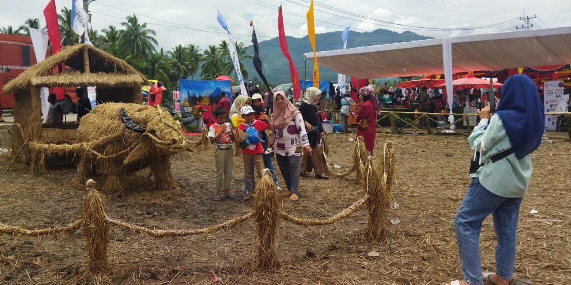 Pengunjung Manfaatkan Hiasan Jerami Berbentuk Kerbau untuk Abadikan Momen Bersama Keluarga