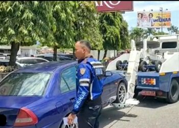 Petugas Dishub Padang derek sebuah mobil parkir sembarangan di depan Basko Grand Mall